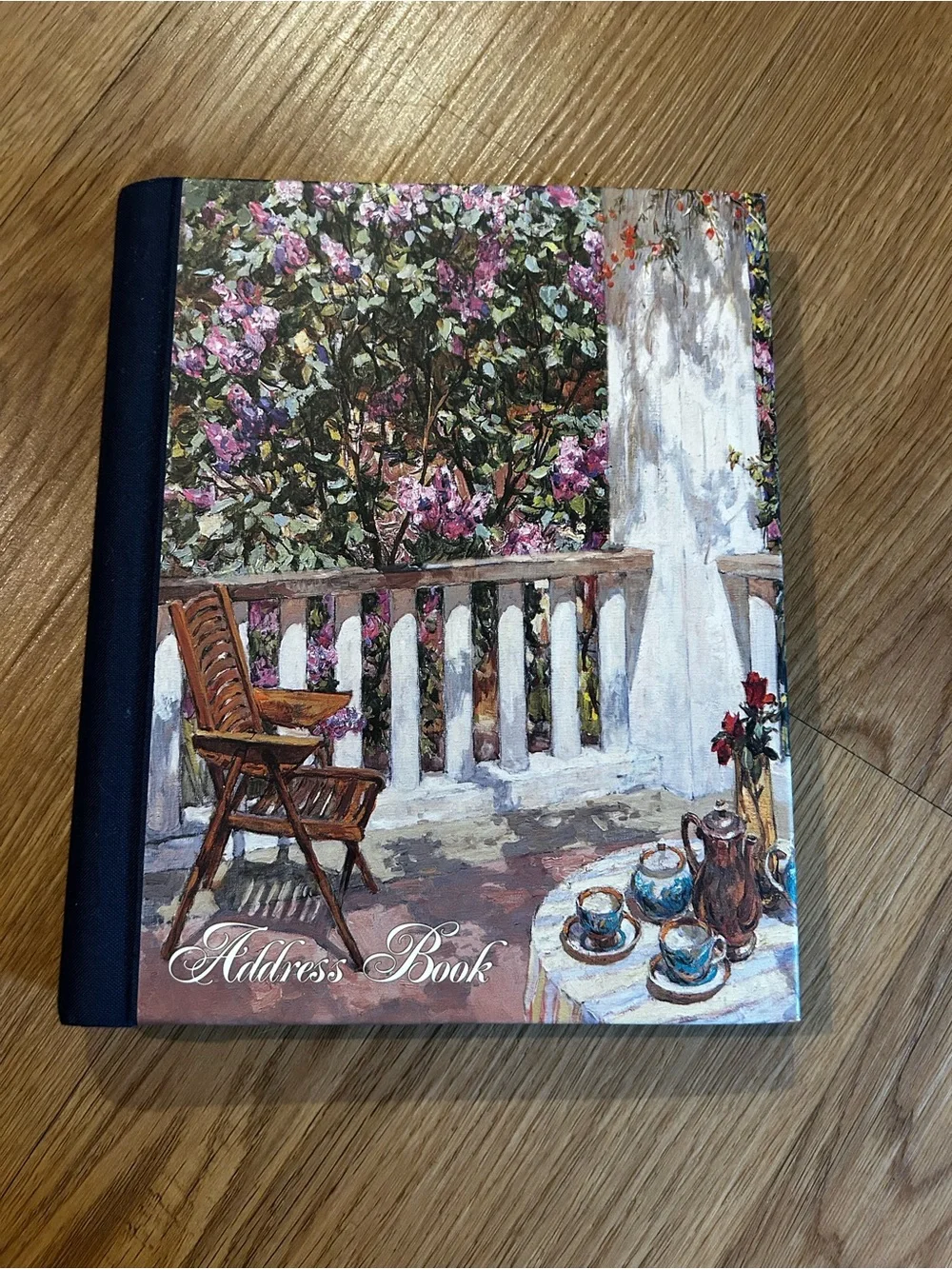 Hardcover spiral address book with floral garden artwork cover
